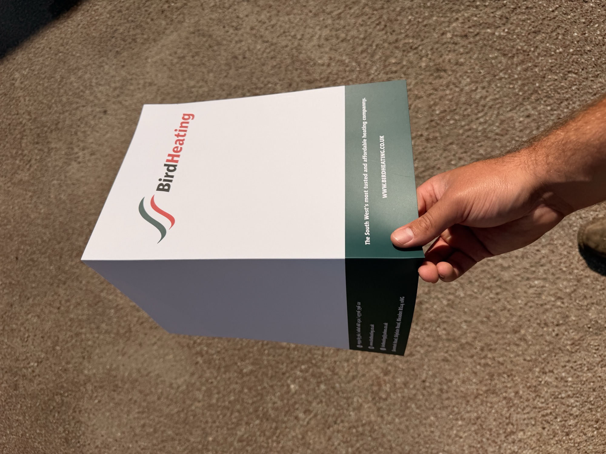 Folded flyer brochure held outdoors on gravel