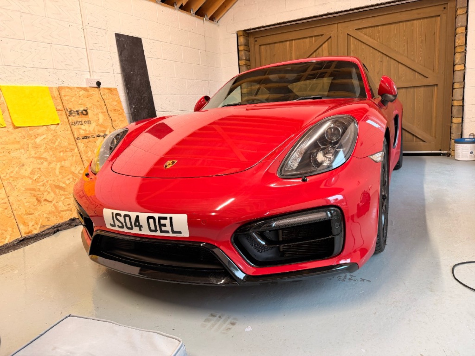 Red Porsche with paint protection film in workshop
