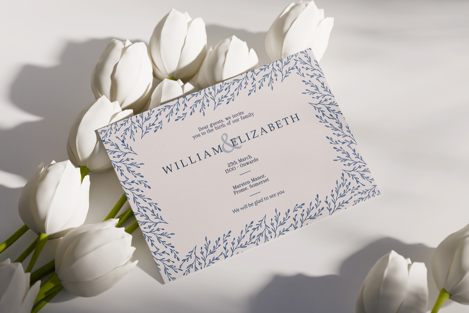 A5 wedding invitation with a blue foliage border among white tulips